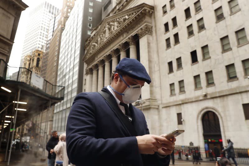 FILE PHOTO: FILE PHOTO: A man wears a protective mask as he walks on Wall Street during the coronavirus outbreak in New York