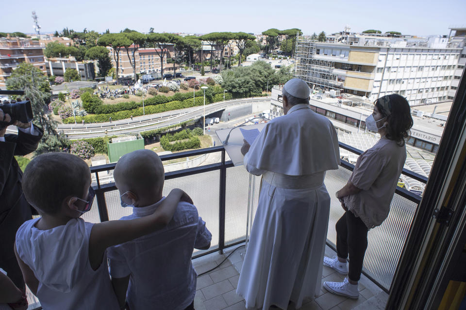 Pope Francis appears with some young oncologic patients at a balcony of the Agostino Gemelli Polyclinic in Rome, Sunday, July 11, 2021, where he was hospitalized for intestine surgery, to deliver his traditional Sunday blessing. (Vatican Media via AP)