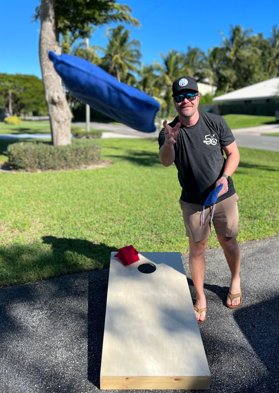 Achievement Centers supporter Steven Murphy demonstrates a cornhole throw.