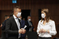 Belgium's Foreign Minister Sophie Wilmes, right, talks to her Hungarian counterpart Peter Szijjarto during a European Foreign Affairs Ministers meeting at the European Council building in Luxembourg, Monday, June 21, 2021. EU foreign ministers were set to approve Monday a new set of sanctions against scores of officials in Belarus and prepare a series of measures aimed at the country's economy. (Johanna Geron/Pool Photo via AP)