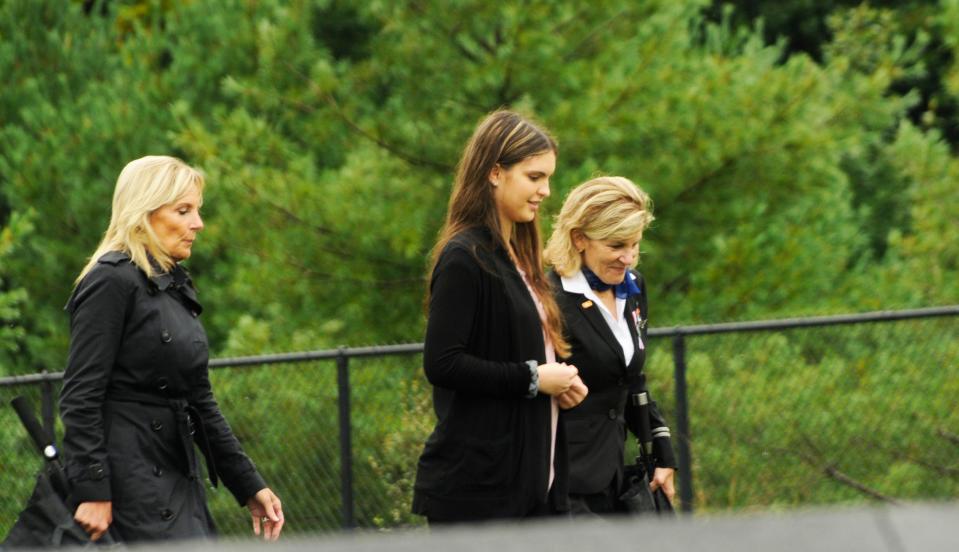 First lady Jill Biden (left) walks with Connie Hasenei, great-niece of passenger Patricia Cushing, and Biden's sister, Bonnie Jacobs, back from a wreath laying ceremony.