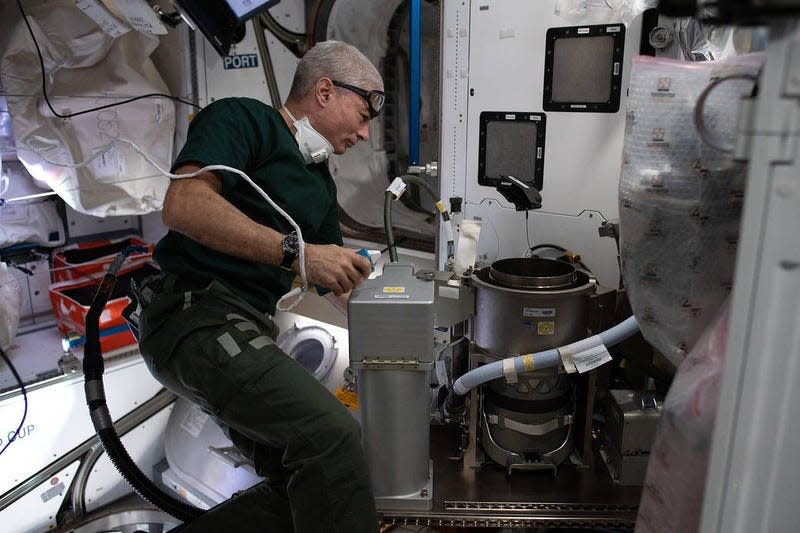 NASA astronaut Mark Vande Hei working on an advanced new toilet during installation in 2021.