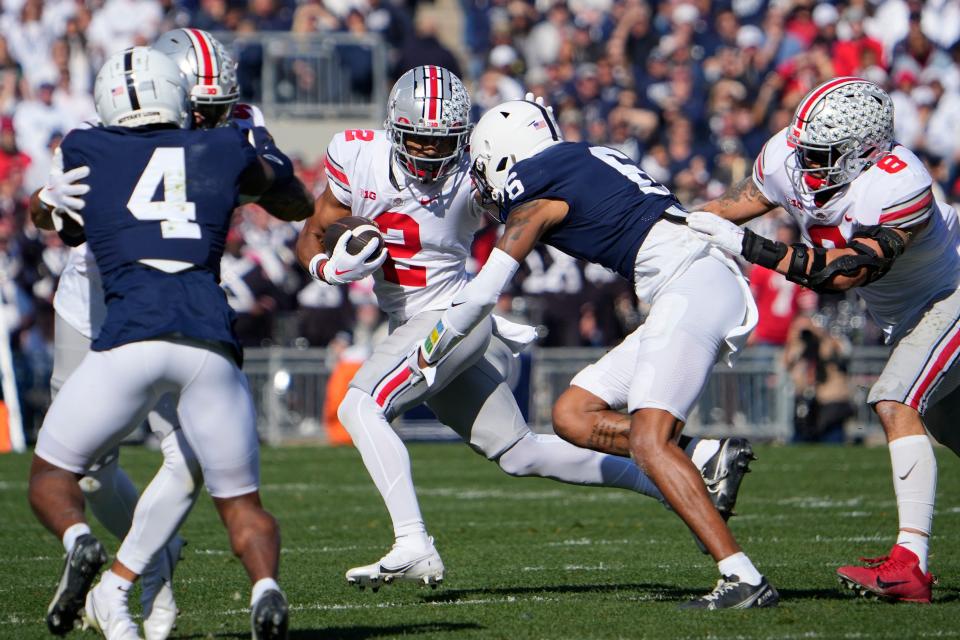 Ohio State wide receiver Emeka Egbuka (2) tries to avoid Penn State safety Zakee Wheatley during the first half at Beaver Stadium.