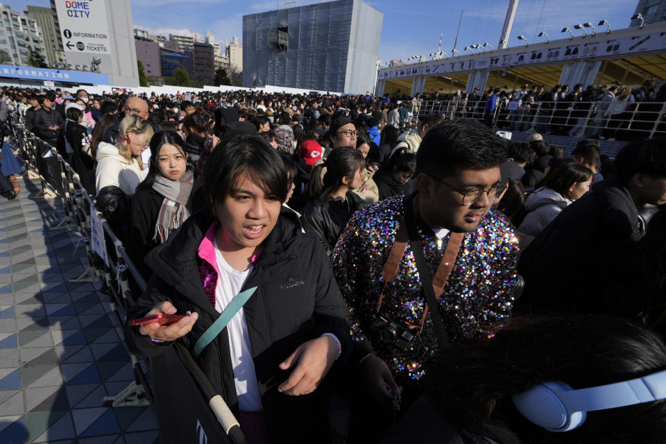 People wait in line to receive their reserved tickets before Taylor Swift's concert at Tokyo Dome in Tokyo, Saturday, Feb. 10, 2024. (AP Photo/Hiro Komae)