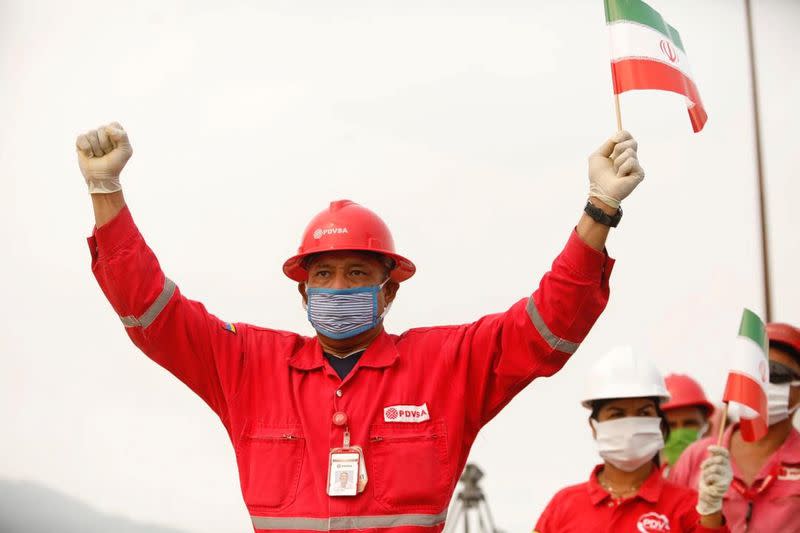 FILE PHOTO: A worker of the state-oil company Pdvsa holds an Iranian flag during the arrival of the Iranian tanker ship "Fortune" at El Palito refinery in Puerto Cabello
