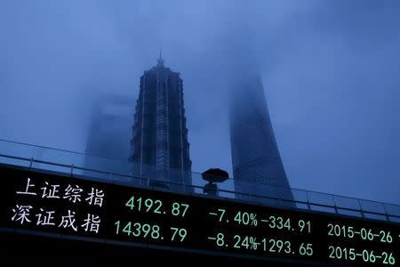 A man walks past an electronic board showing the benchmark Shanghai and Shenzhen stock indices, on a pedestrian overpass at the Pudong financial district in Shanghai, China, in this June 26, 2015 file photo. REUTERS/Aly Song/FIles