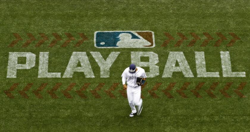 FILE - San Diego Padres left fielder Allen Cordoba passes a logo for Play Ball, an initiative from Major League Baseball and USA Baseball, during the fifth inning of a baseball game against the Colorado Rockies on June 3, 2017, in San Diego. Players voted Thursday, March 10, 2022, to accept MLB's offer on new labor deal, paving way to end 99-day lockout and salvage 162-game season. (AP Photo/Gregory Bull, File)