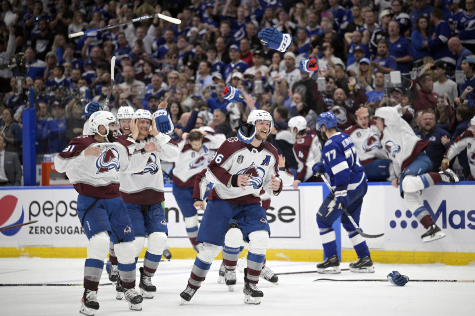 Gloves and sticks are tossed as the Colorado Avalanche celebrate winning the Stanley Cup against the Tampa Bay Lightning in Game 6 of the NHL hockey Stanley Cup Finals on Sunday, June 26, 2022, in Tampa, Fla. (AP Photo/Phelan Ebenhack)