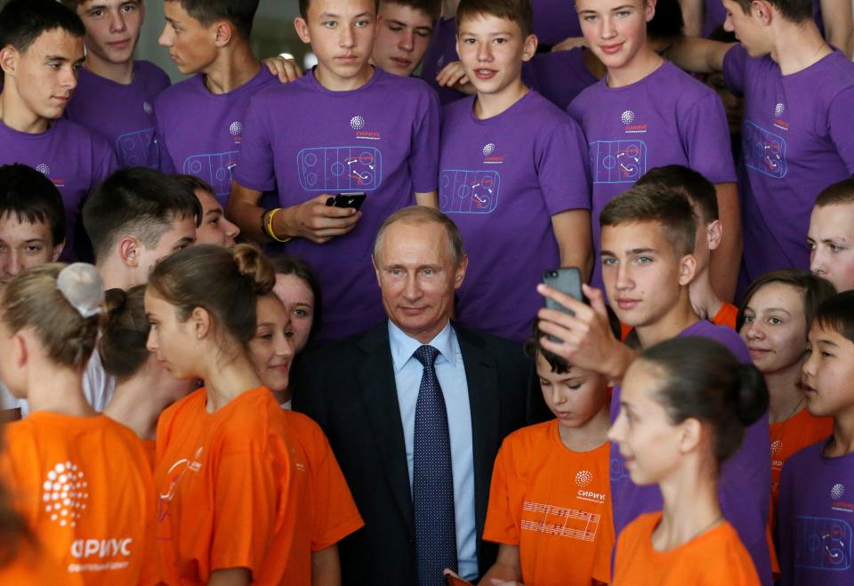 Russian President Vladimir Putin poses with students.