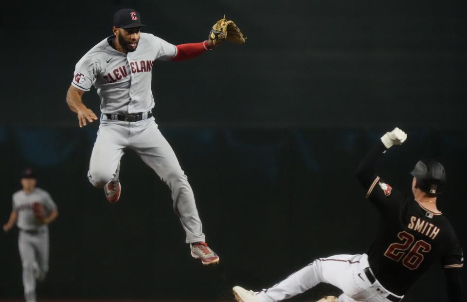 Jun 17, 2023;  Phoenix, AZ, USA;  Cleveland Guardians infielder Amed Rosario (1) leaps over Arizona Diamondbacks Pavin Smith (26) while throwing to first base for the double play at Chase Field.