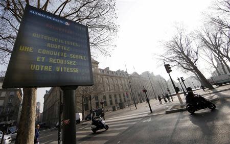 A Paris city information board which reads, "Pollution - Drivers slow down your speed", is seen along a street in Paris March 14, 2014, as warm and sunny weather continues in France. REUTERS/Jacky Naegelen