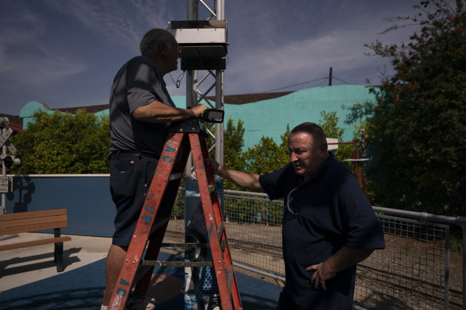 Kevin Kinne, right, a 63-year-old maintenance manager, pauses for a moment while helping Lester Green install bubble machines ahead of reopening at Adventure City amusement park in Anaheim, Calif., Thursday, April 15, 2021. Kinne was let go after the coronavirus pandemic forced the family-run amusement park to close in March 2020. "Oh God, I wanted to come back to work so bad," Kinne said. "We are a small park so we all know each other. We are all friends." (AP Photo/Jae C. Hong)
