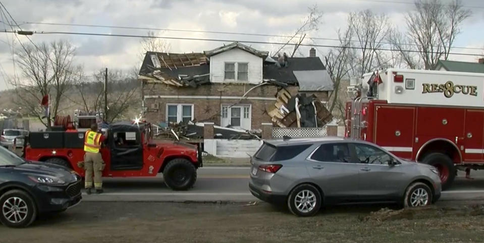 In this frame grab taken from video from WHAS, first responders stage outside a home in Milton, Ky., Thursday, March 14, 2024, after a severe weather system came through the area. (WHAS via AP)