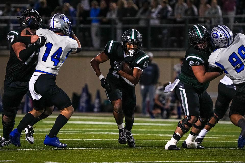 Cedar Park running back Trae Hill tries to elude Georgetown defender Mason Goggans. Hill rushed for 100 yards and a touchdown in the Timberwolves' 28-21 win. Cedar Park has won four straight games heading into the playoffs.