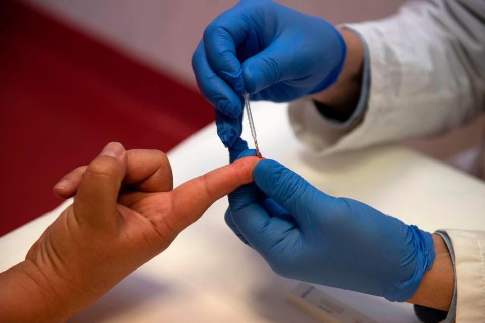 A person undergoes a finger prick blood sample as part of of an antibody rapid serological test for COVID-19 on May 6, 2020.