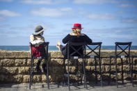 Women sit in a caffe-bar overlooking the Mediterranean Sea as restrictions are eased following months of government-imposed shutdowns, in Tel Aviv, Israel, Sunday, March 7, 2021. Israel reopened most of its economy Sunday as part of its final phase of lifting coronavirus lockdown restrictions, some of them in place since September. (AP Photo/Ariel Schalit)