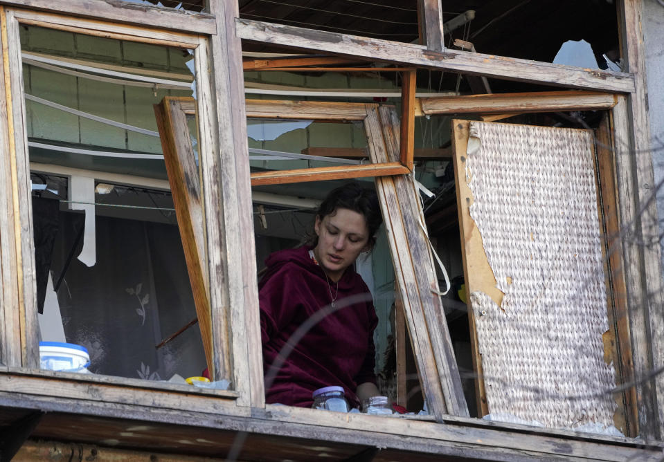 A women stands near a broken window in her apartment after a Russian bombing attack in Kyiv, Ukraine, Monday, March 14, 2022. (AP Photo/Efrem Lukatsky)