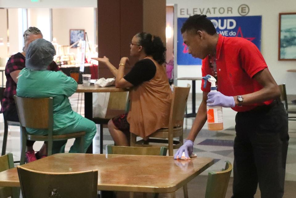 Project SEARCH student Torrey Sloss cleans tables in the café, Thursday, Dec. 15, 2022, at Halifax Health Medical Center in Daytona Beach. Project SEARCH is a national program for students with disabilities who complete one-year internships to gain work experience and employability skills.