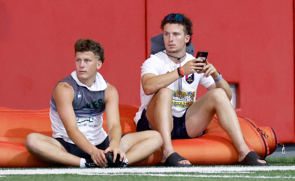 Heritage High School’s Lex Thomas, left, and his brother, N.C. State receiver Thayer Thomas, watch drills at the Close-King Indoor Practice Facility in Raleigh, N.C., on Thursday, June 16, 2022.