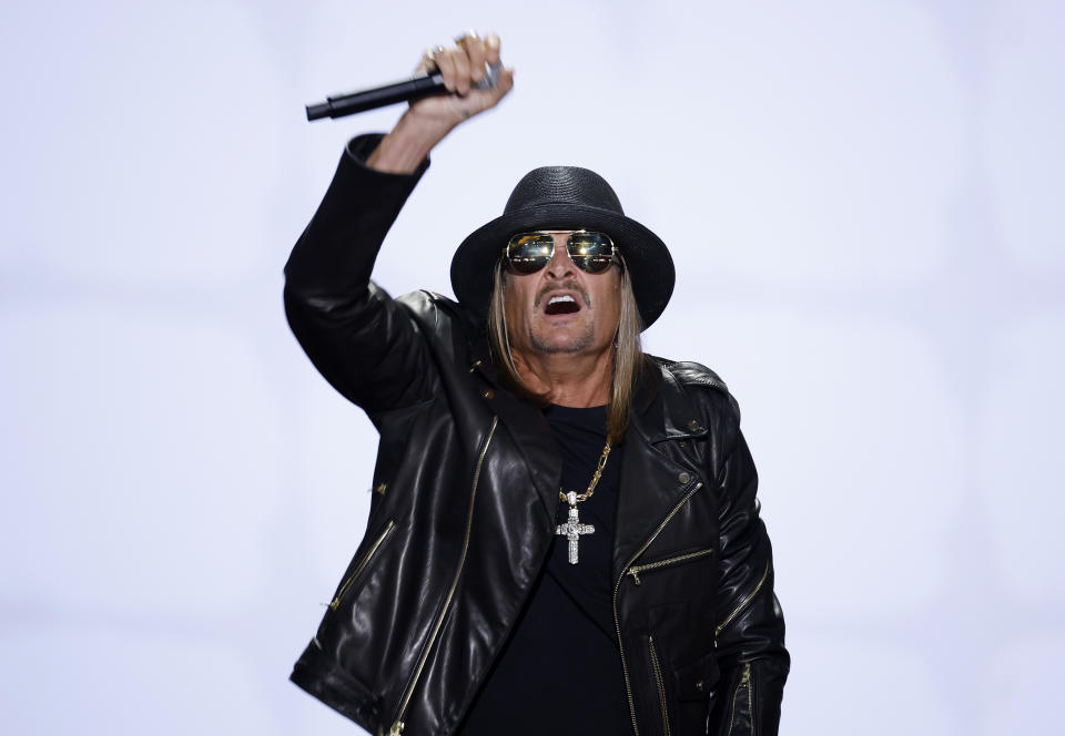 Kid Rock tritt auf der Bühne auf und trägt eine schwarze Lederjacke, einen schwarzen Hut und eine Sonnenbrille und hält ein Mikrofon