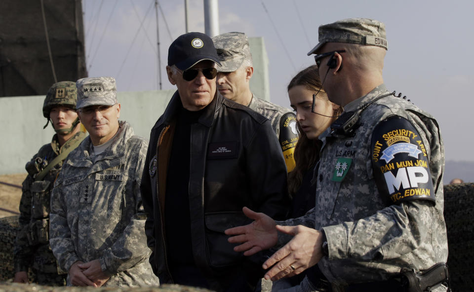 FILE - Vice President Joe Biden, center, is briefed by Lt. Col. Daniel Edwan, the commander of the JSA Security Battalion from Observation Post Ouellette during his tour of the Demilitarized Zone (DMZ), near the border village of Panmunjom, which has separated the two Koreas since the Korean War, South Korea, Dec. 7, 2013. When the U.S. and South Korean leaders meet Saturday, May 21, 2022, North Korea’s nuclear weapons and missile program, already a major focus, may receive extra attention if intelligence predictions of an imminent major weapons demonstration by the North, which is struggling with a COVID-19 outbreak, are right. (AP Photo/Lee Jin-man, File-Pool)