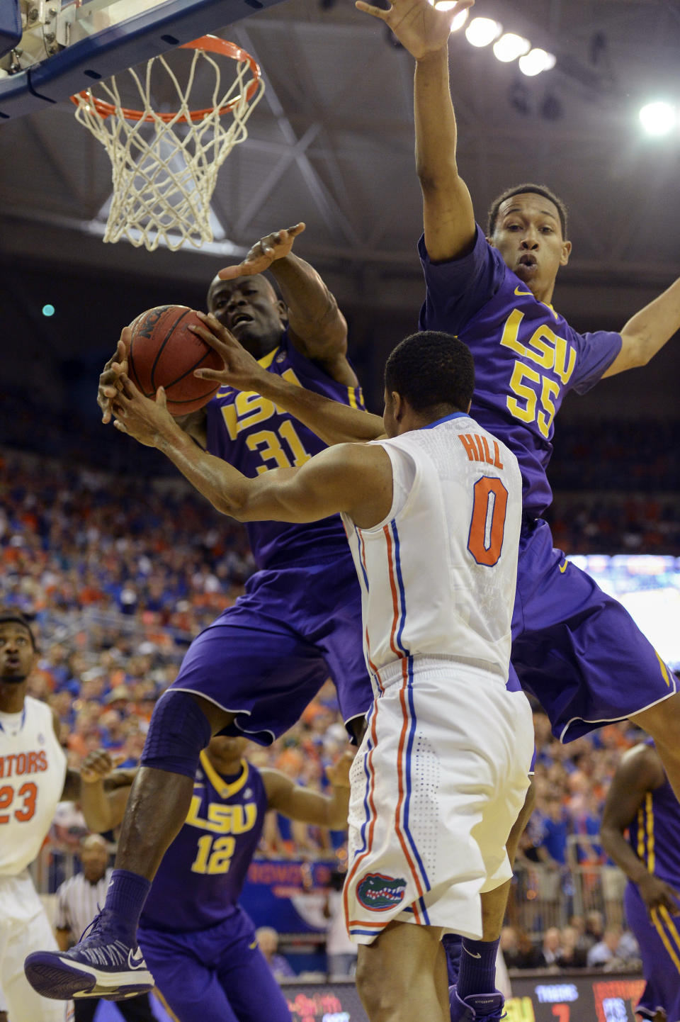 LSU forward John Odo (31) and LSU guard Tim Quarterman (55) go up to block a shot by Florida's Kasey Hill during the first half of an NCAA college basketball game on Saturday, March 1, 2014, in Gainesville, Fla. (AP Photo/Phil Sandlin)