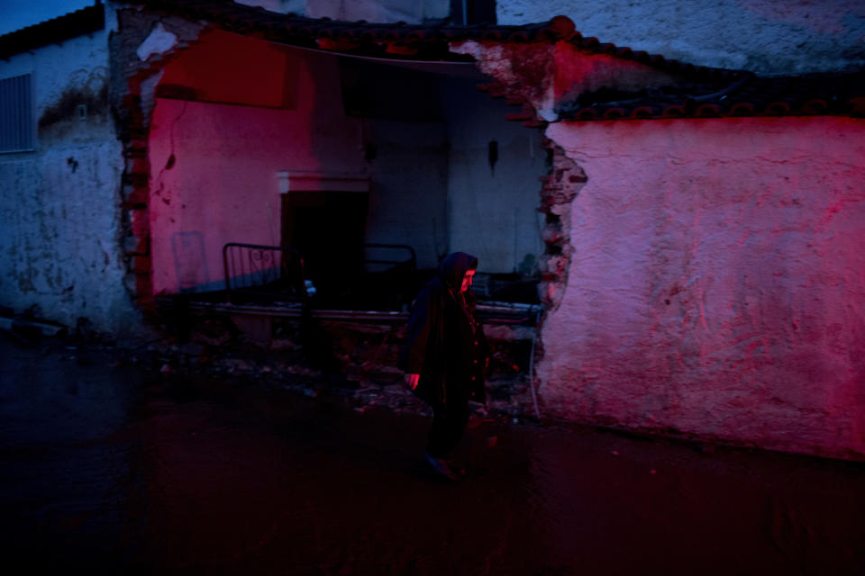 <p>A elderly woman walks in front of a damaged house in the town of Mandra western Athens, on Friday , Nov. 17, 2017. (Photo: Petros Giannakouris/AP) </p>