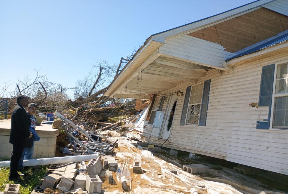 People survey damage at a tornado-damaged home in Adamsville, Tenn., on Saturday, April 1, 2023.