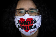 A demonstrators attends a protest to demand more resources for public health system in Madrid, Spain, Sunday, Nov. 29, 2020. The organizers delivered a manifesto to the Madrid regional authorities demanding the end privatization of the health system. The face mask reads in Spanish "Public health system". (AP Photo/Bernat Armangue)