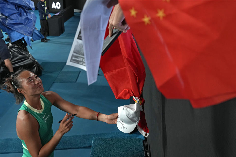 Zheng Qinwen of China signs autographs after defeating Oceane Dodin of France in their fourth round match at the Australian Open tennis championships at Melbourne Park, Melbourne, Australia, Monday, Jan. 22, 2024. (AP Photo/Louise Delmotte)