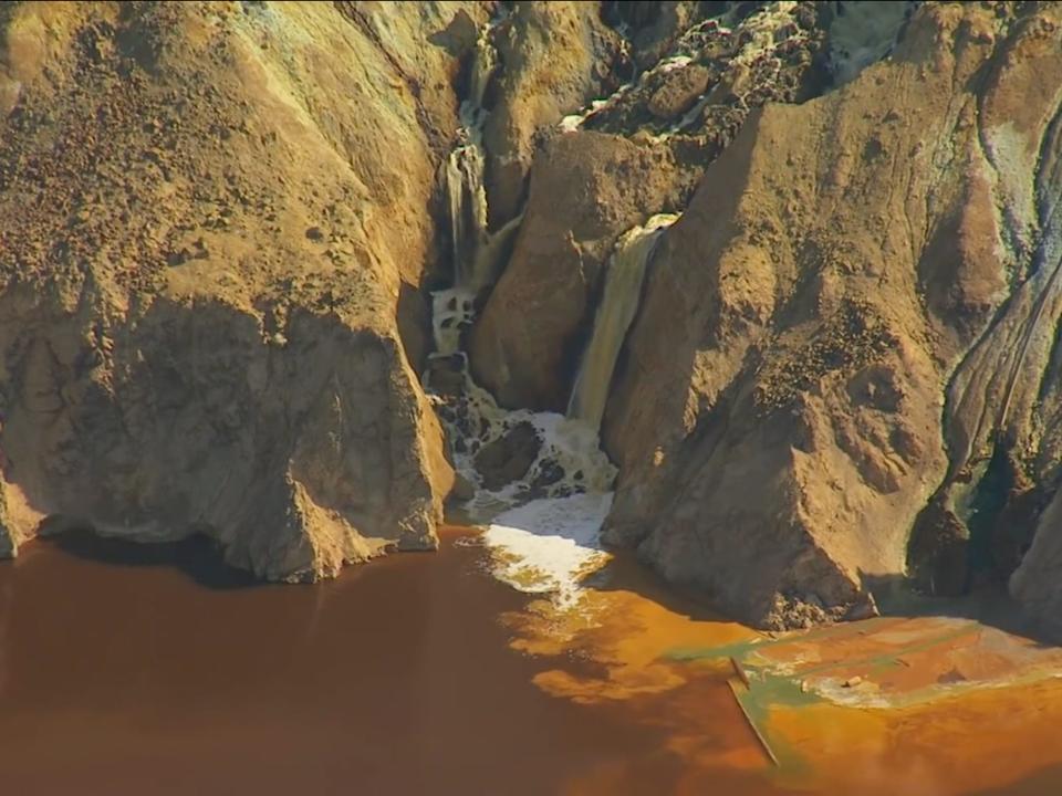 Tailings from a mining operation draining into a body of water.