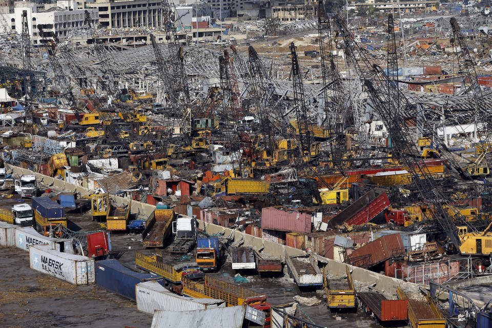 FILE - In this Monday, Aug. 10, 2020 file photo, rows of destroyed trucks are seen at the site of the Aug. 4 explosion that hit the seaport of Beirut, Lebanon. It was 20 minutes before 6:08 p.m. when the Beirut fire brigade received the call from an employee at the nearby port reporting a big fire. Ten firefighters, including a female paramedic, piled into a fire engine and an ambulance and raced toward the scene, and their ultimate death. (AP Photo/Bilal Hussein, File)