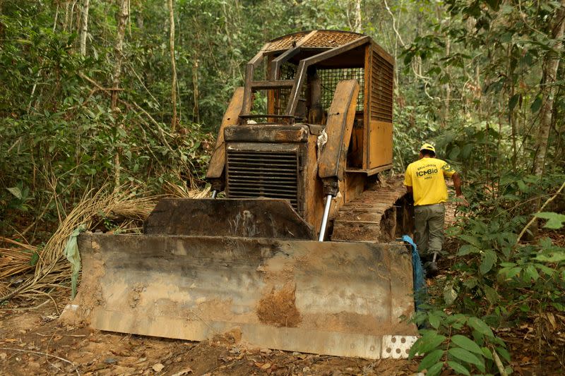 FILE PHOTO: FILE PHOTO: A member of the Chico Mendes Institute for Biodiversity Conservation (ICMBio) walks next a tractor used for deforestation at the National Forest Bom Futuro in Rio Pardo