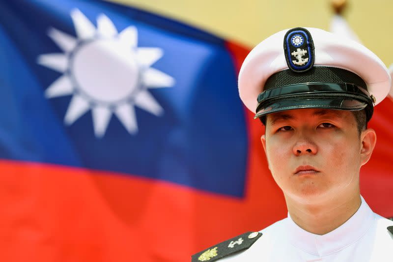 FILE PHOTO: A Taiwan Navy honor guard looks on in front of a Taiwan flag during the launch ceremony for Taiwan Navy's domestically built amphibious transport dock "Yushan" in Kaohsiung