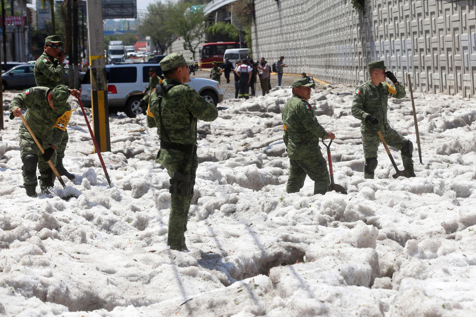 Soldiers try to clear away ice after a heavy storm of rain and hail which affected some areas of the city in ??Guadalajara, Mexico June 30, 2019. REUTERS/Fernando Carranza