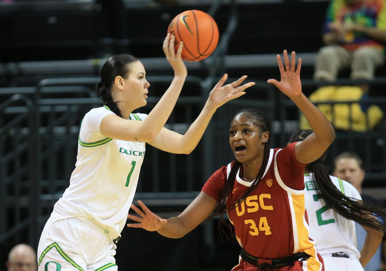 Oregon's Kennedy Basham passes the ball under pressure from USC's Clarice Akunwafo during the first half of their Pac-12 game at Matthew Knight Arena Sunday, Jan. 1, 2023 in Eugene, Oregon.