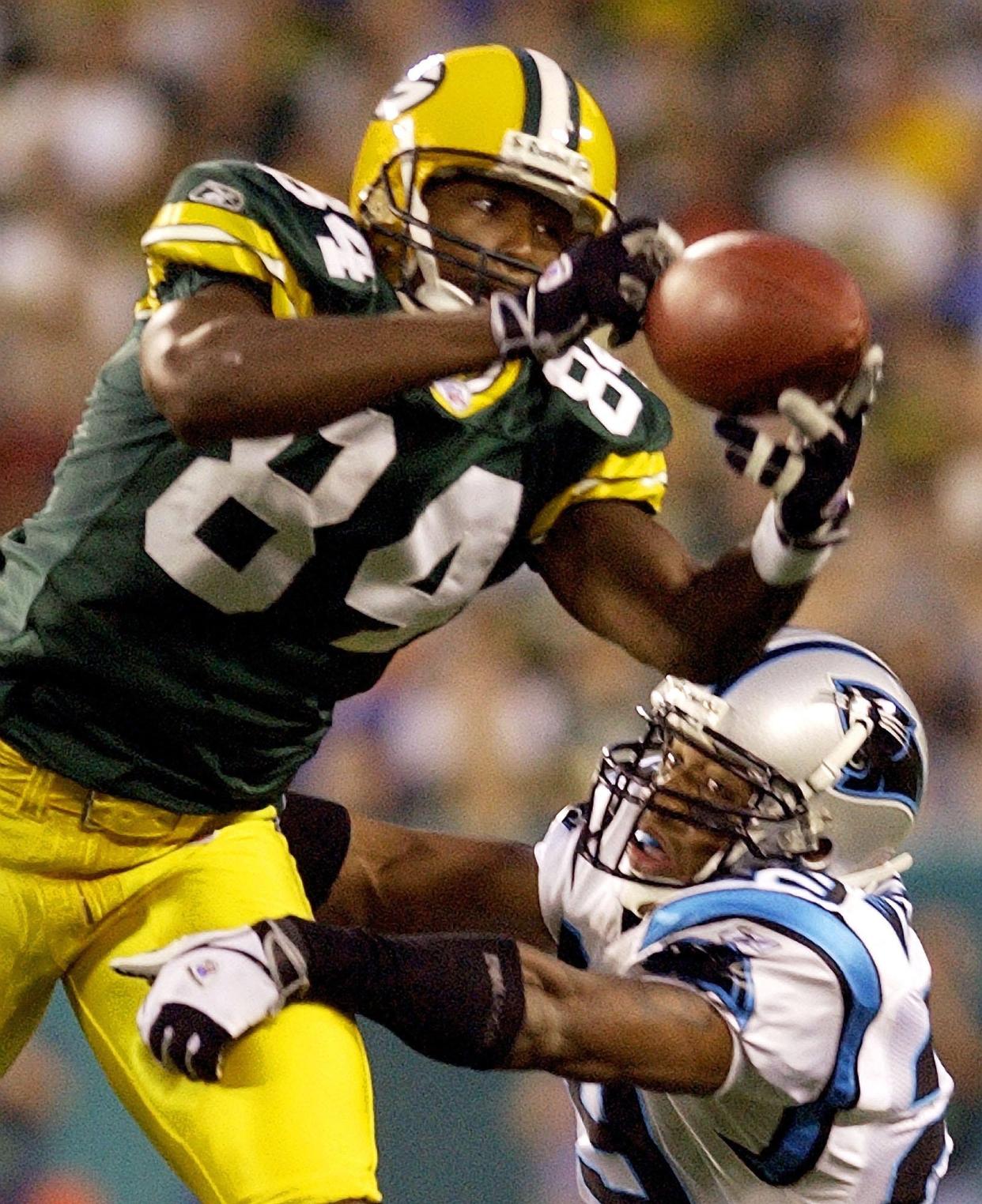 Green Bay Packers receiver Javon Walker catches a pass in front of Carolina Panthers cornerback Dante Wesley.