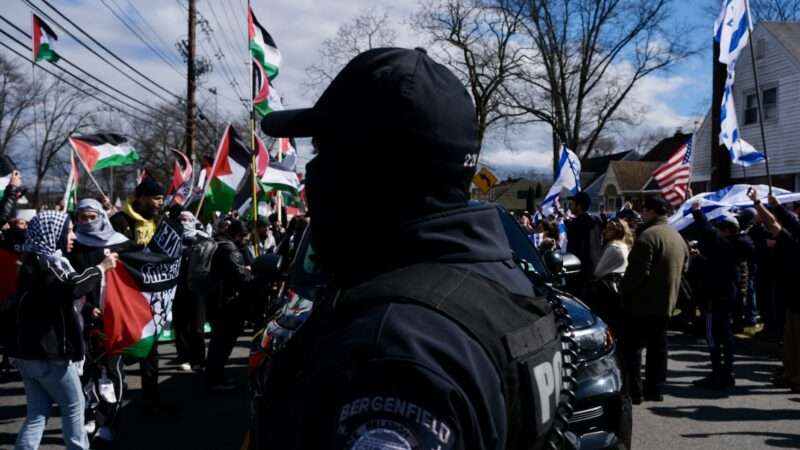 A police officer stands between pro-Palestinian and pro-Israeli protesters in Teaneck, New Jersey on March 10, 2024.