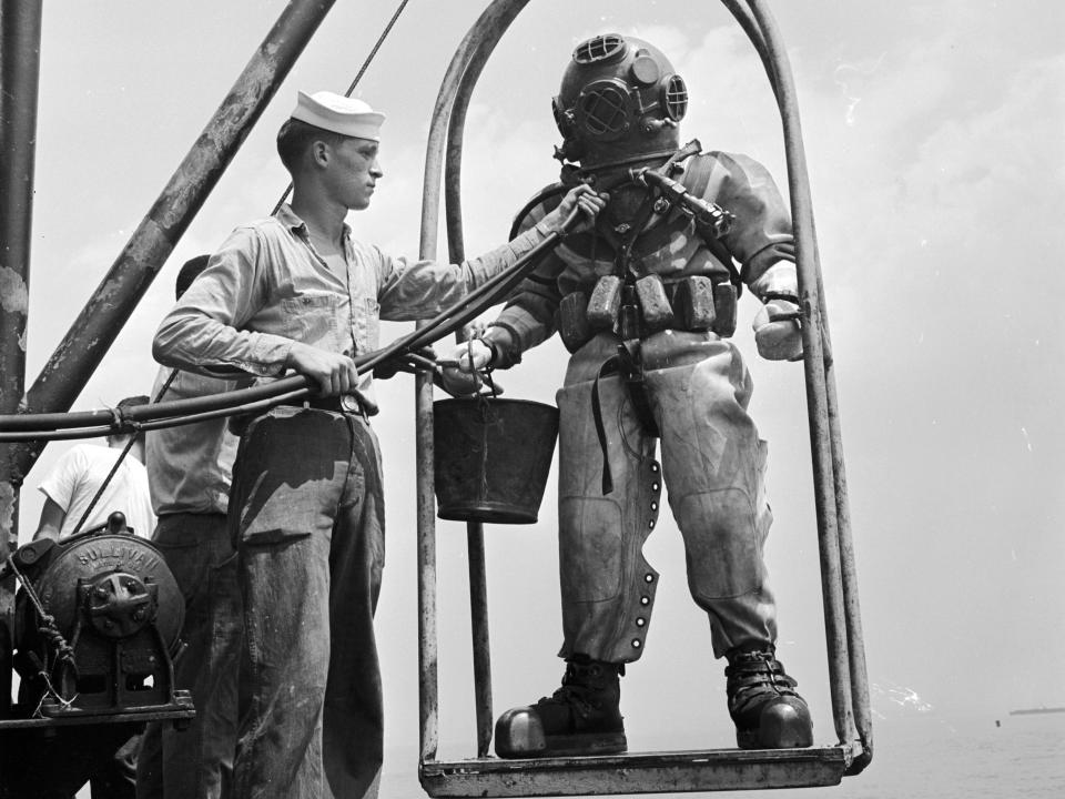 A US navy diver on a ‘diving stage’ before a dive in 1955.