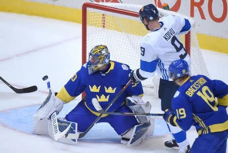 Sep 20, 2016; Toronto, Ontario, Canada; Team Sweden goalie Henrik Lundqvist (30) makes a save in front of Team Finland forward Mikko Koivu (9) during preliminary round play in the 2016 World Cup of Hockey at Air Canada Centre. Mandatory Credit: Dan Hamilton-USA TODAY Sports