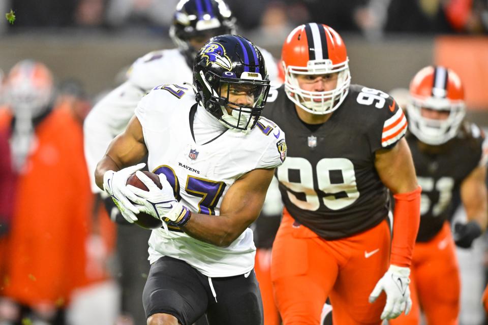 Baltimore Ravens running back J.K. Dobbins (27) runs past Cleveland Browns defensive tackle Taven Bryan (99) on Dec. 17, 2022.