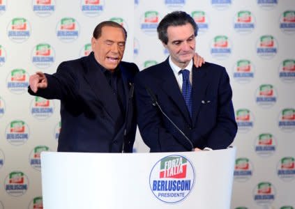 Italian leader of the centre-right party Forza Italia Silvio Berlusconi gestures as he speaks flanked by mayor of Varese Attilio Fontana (R) during a pre-election gathering in Milan, Italy February 25, 2018.  REUTERS/Massimo Pinca