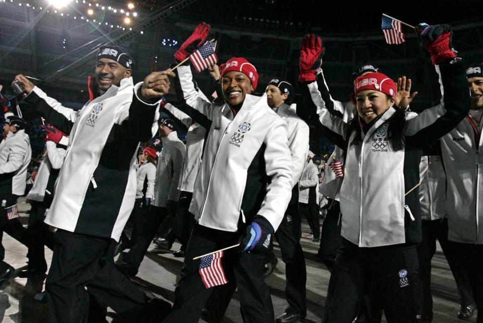 <p>Famous figure skater Michele Kwan (right) and bobsledder Vonetta Flowers, (center) wave to the crowd in their Opening Ceremony uniforms. (AP) </p>