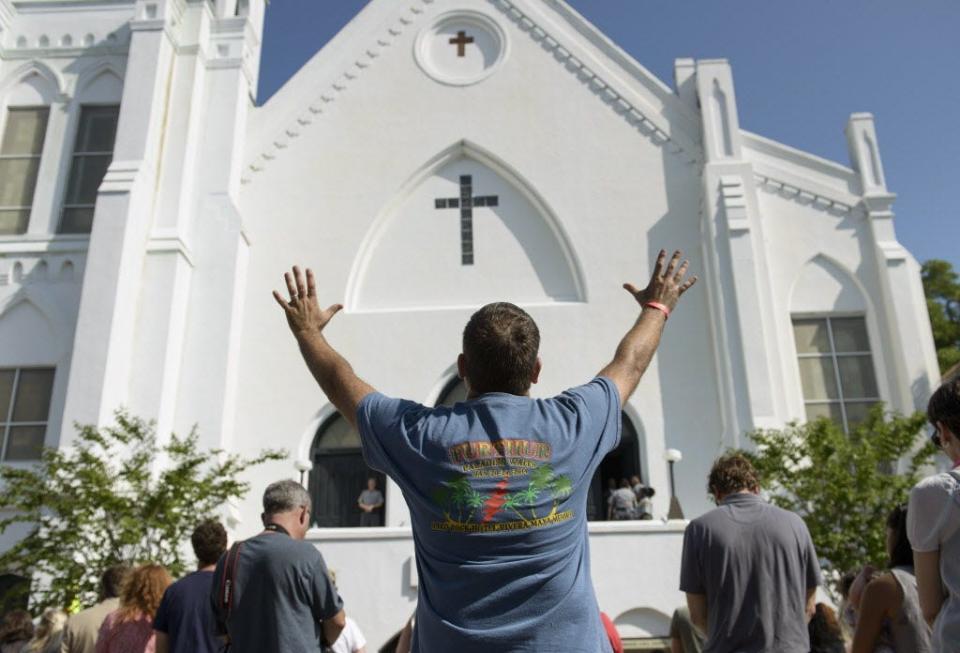 People listen to the Sunday service outside the Emanuel AME Church Sunday in Charleston, S.C. Large crowds gathered for the service, the first since nine African Americans were gunned down Wednesday evening during bible study at the historic church.
