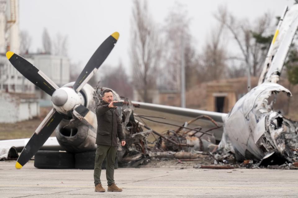 Ukrainian President Volodymyr Zelenskyy does a livestream on his phone during a ceremony at Hostomel Airport in Kyiv on Saturday, February 24, 2024. The ceremony marks the second anniversary of the start of the war in Ukraine.