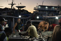 Men gather at a fish market in Manaus, Brazil, May 22, 2020. Although health experts warn that the COVID-19 pandemic is far from over in Manaus, or across the country, national polls show adherence to lockdowns and quarantines falling, and a growing percentage of Brazilians are neglecting local leaders' safety recommendations. (AP Photo/Felipe Dana)