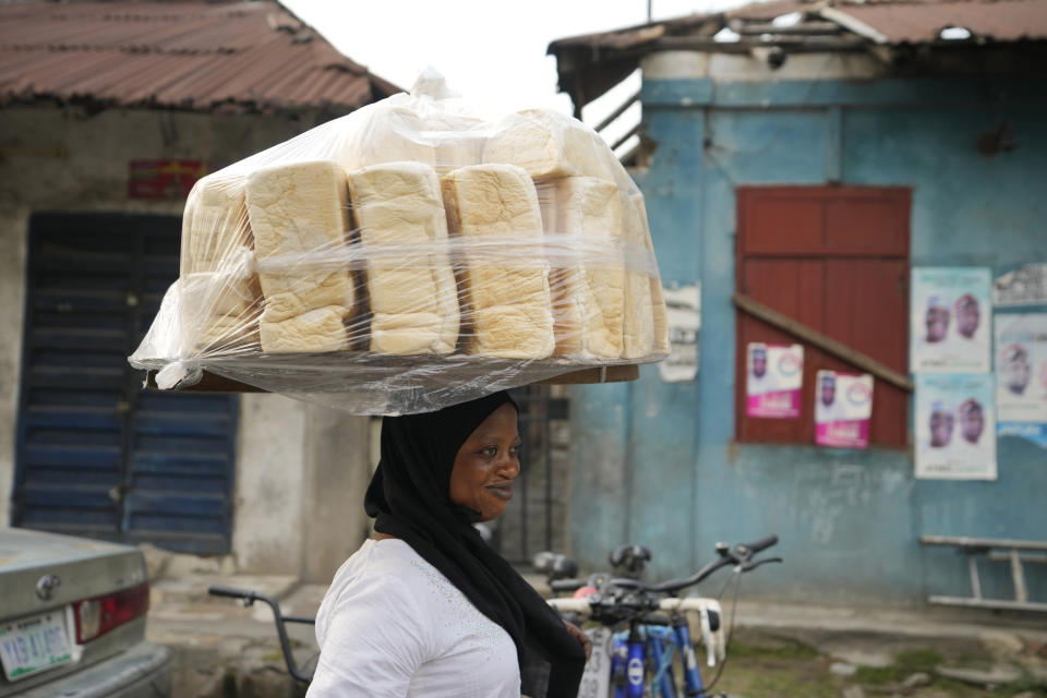 A woman sells bread on a street in Lagos, Nigeria, on Friday, Feb. 3, 2023. Nearly a year after Russia invaded Ukraine, the global economy is still enduring the consequences — crunched supplies of grain, fertilizer and energy along with more inflation and economic insecurity. One official in Nigeria said, “A lot of people have stopped eating bread; they have gone for alternatives because of the cost.’’ (AP Photo/Sunday Alamba)