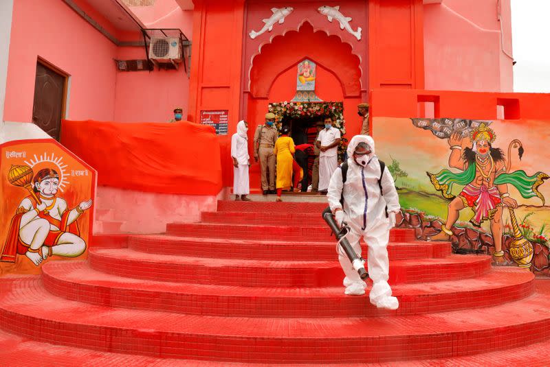 A municipal worker wearing protective gear sprays disinfectant at Hanuman Garhi temple before the arrival of India's Prime Minister Narendra Modi ahead of the foundation laying ceremony for a Hindu temple in Ayodhya