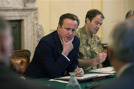 Britain's Prime Minister David Cameron (C) listens during a Cobra meeting at Number 10 Downing Street in London February 12, 2014. REUTERS/Neil Hall