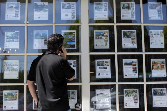 Chad Wootton looks at the listings of homes for sale while talking on the phone in Los Angeles. (Jae C. Hong, AP Photo)